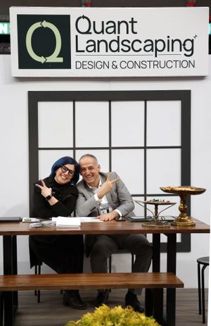 Interior view of Quant Landscaping office with two people sitting at a wooden table.