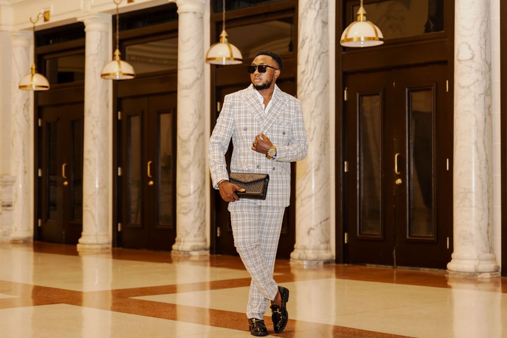 Fashion model poses in elegant hallway with classical columns.