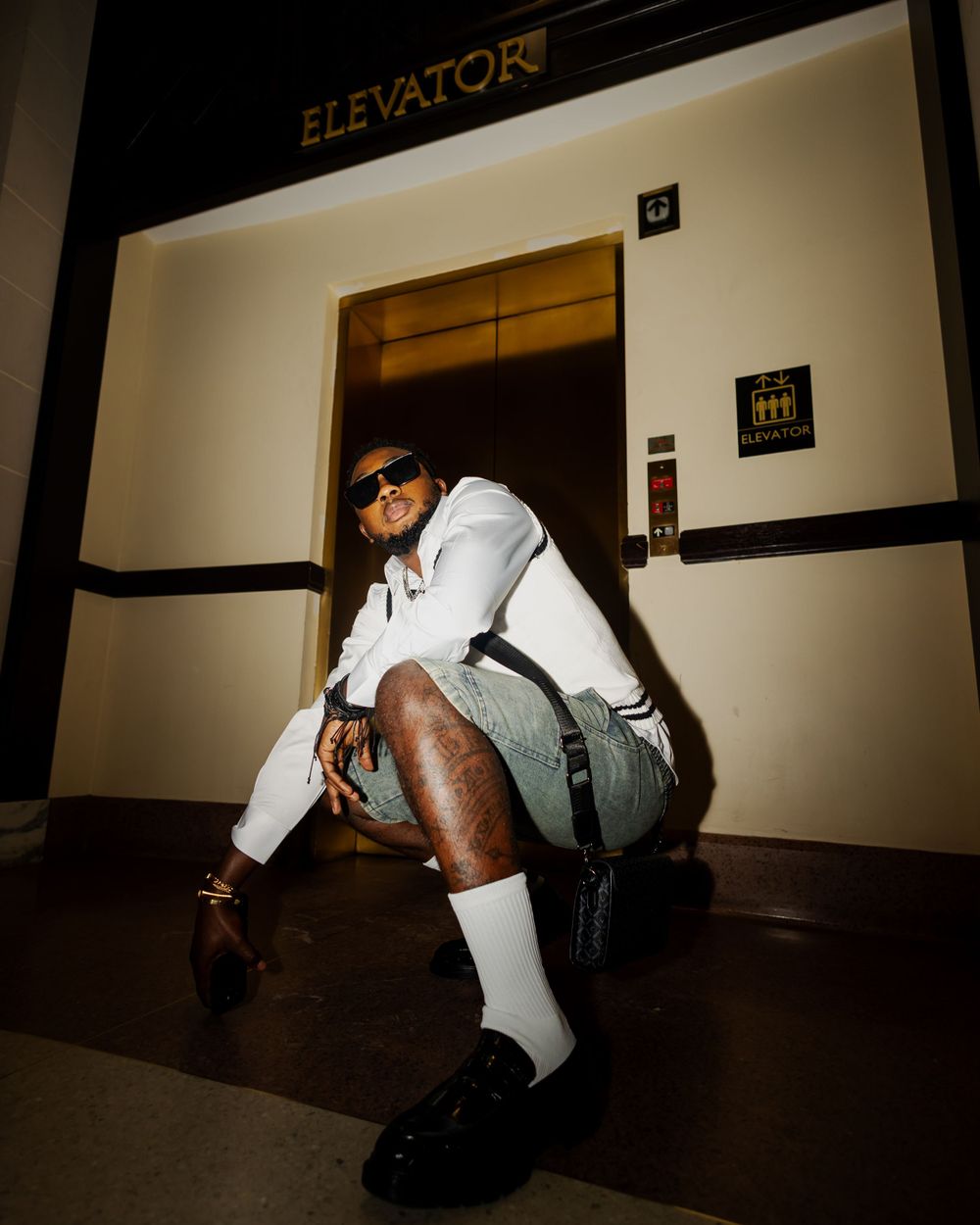 Dramatic low-angle shots of someone crawling near an elevator in a dimly lit hallway.