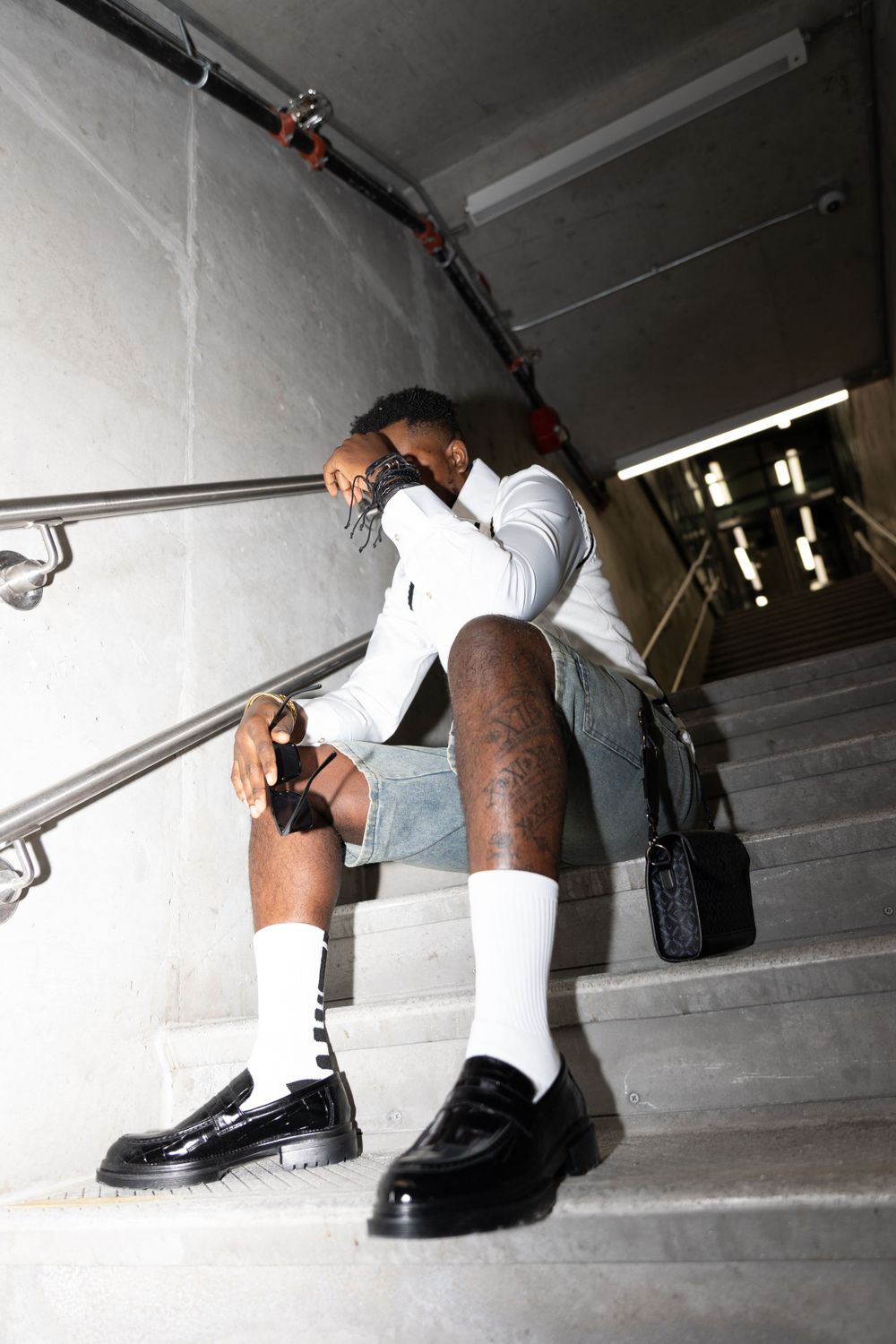 Low angle view of black boots and white socks on concrete stairs.
