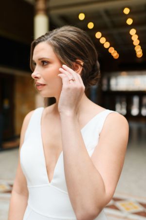 Elegant fashion portrait in white dress with warm bokeh lighting in background.
