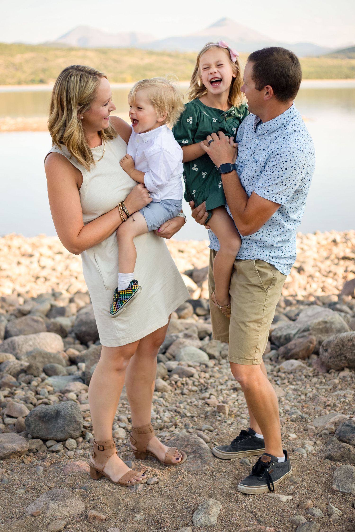 A mom and dad play with their two young children, making them laugh
