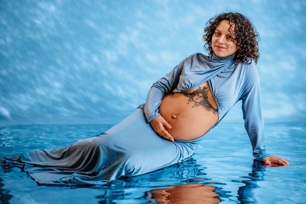Maternity photography sequence showing elegant poses against blue water backdrop.