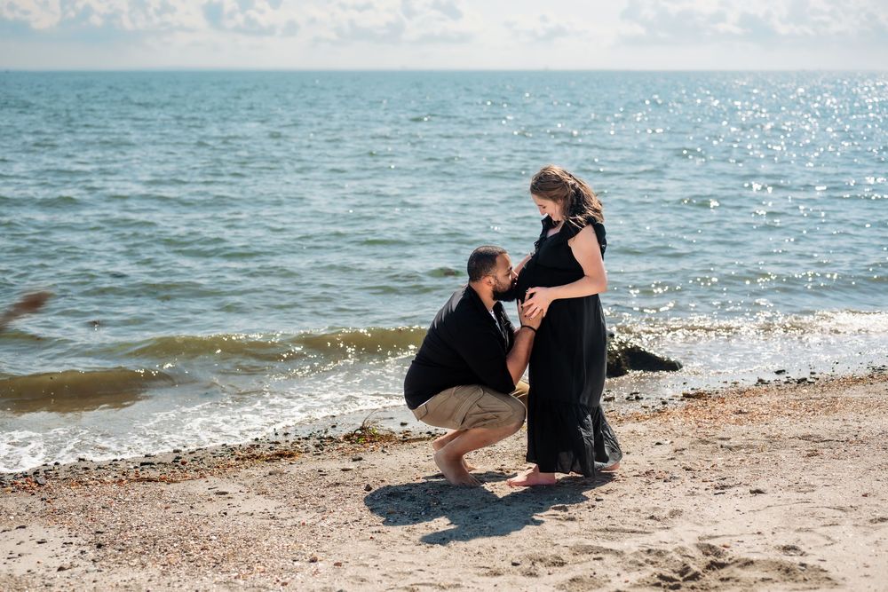 A romantic beach photoshoot with waves crashing on the shore.