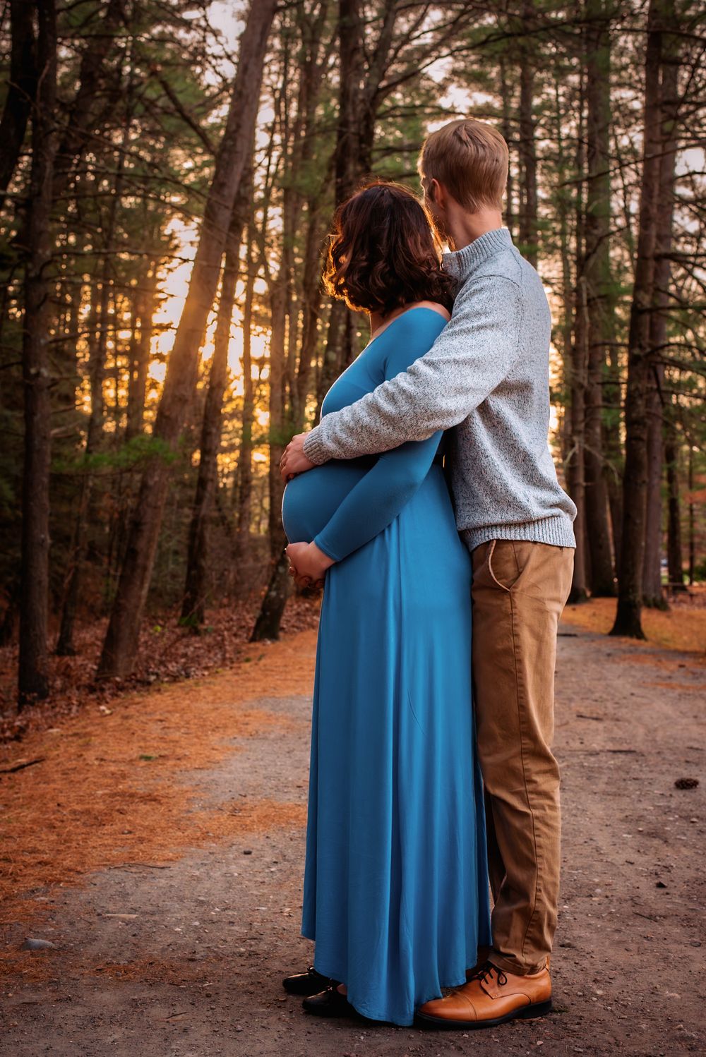 Sweet couple moments captured on winding forest path at sunset.