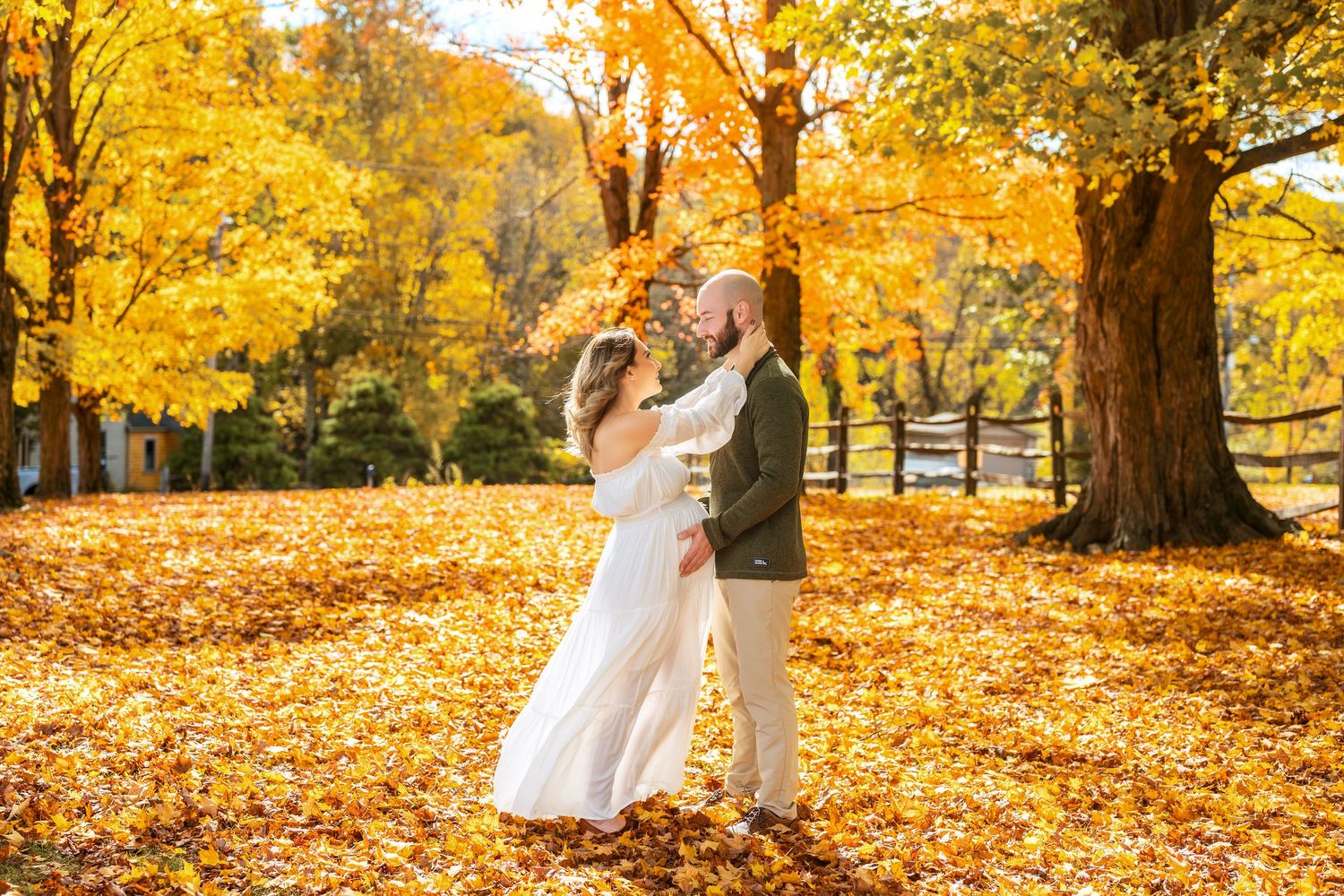 Romantic autumn photography session in a park with golden trees and fallen leaves.