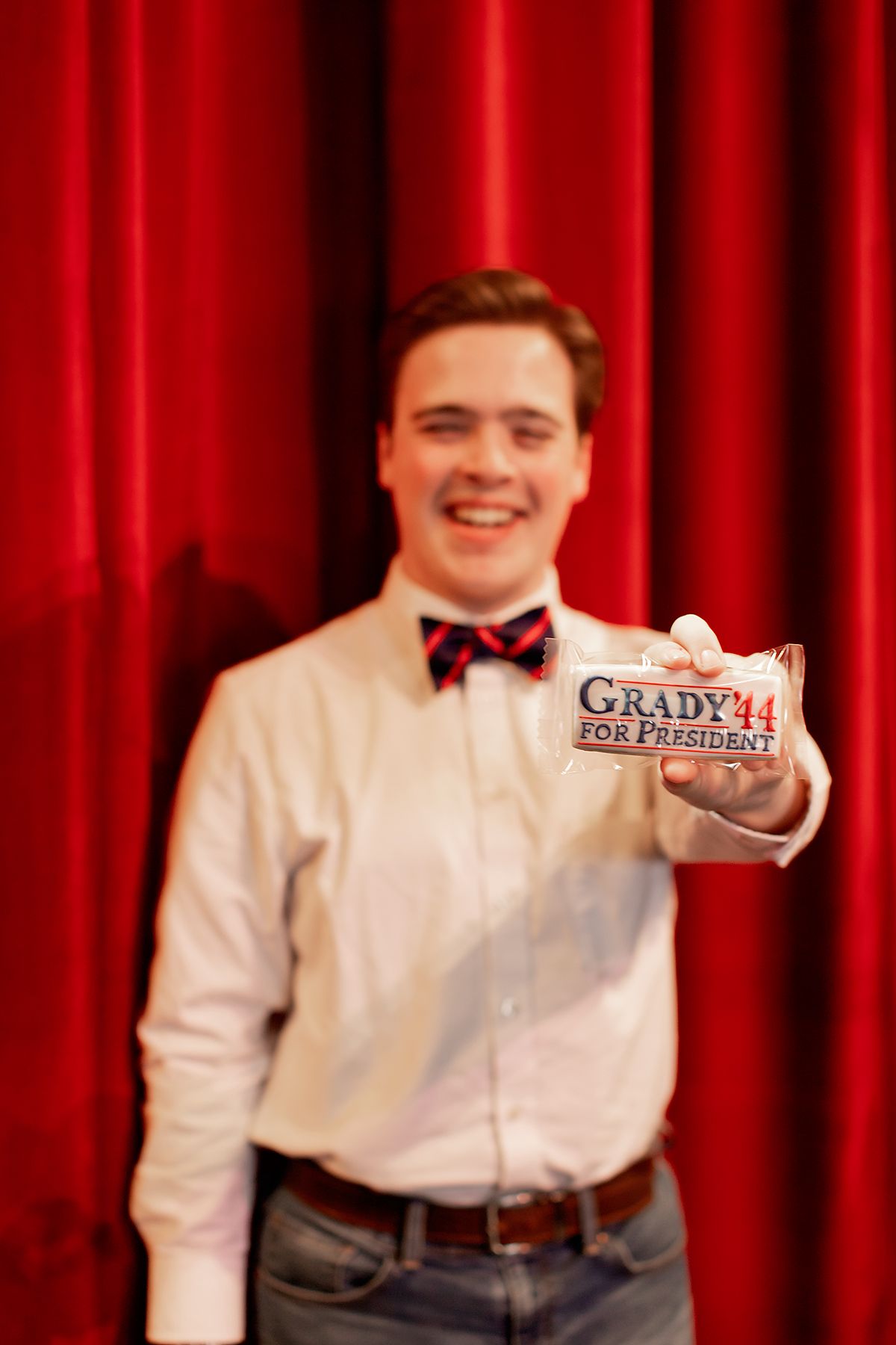 Male teen wearing a button up and bow tie on the stage of the Ned McWherter Theater in Jackson, TN. Senior picture by MegMc Photography
