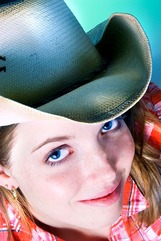 A close-up portrait in western style featuring a  cowboy hat and red plaid shirt. (Ogden New York)