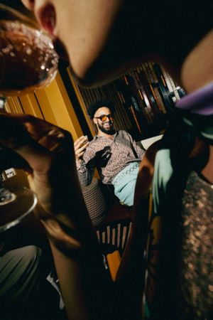 Creative mirror reflection shot captured through doorway showing someone relaxing in chair with dramatic lighting.