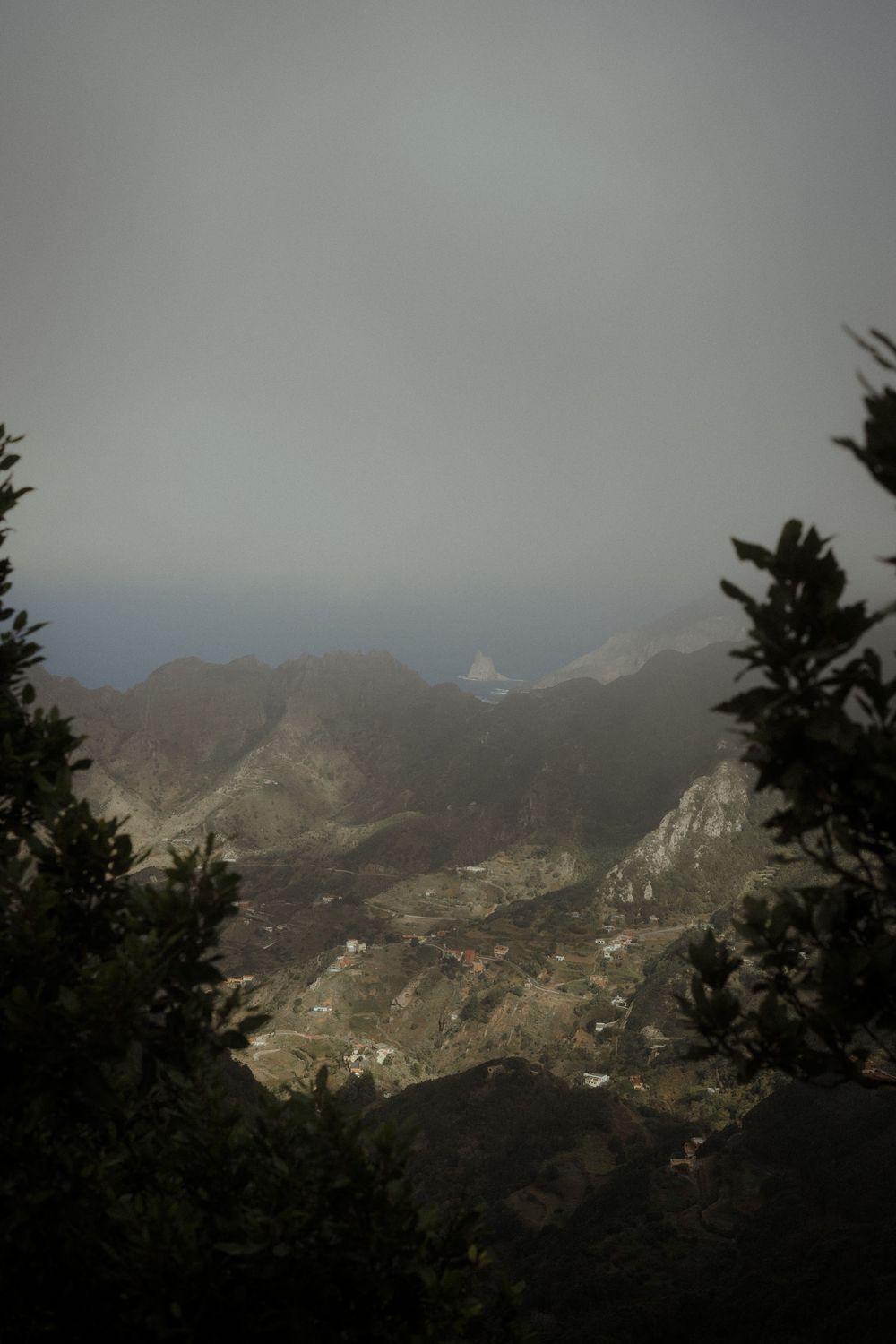 Panoramic mountain landscape view with misty peaks and valleys stretching into the distance under cloudy skies.