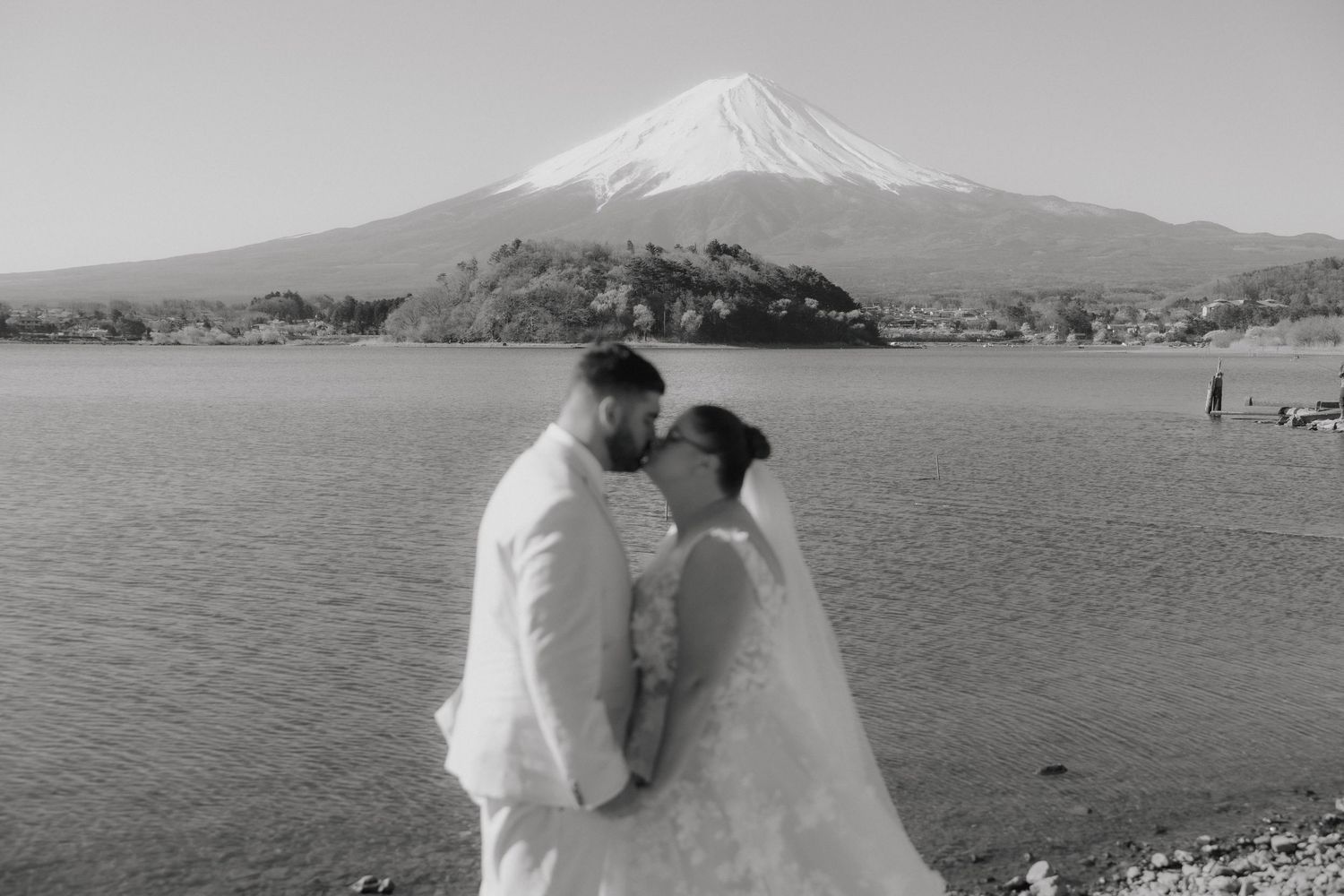 A series of black and white photos showing a couple on their wedding day near Mount Fuji in Japan.