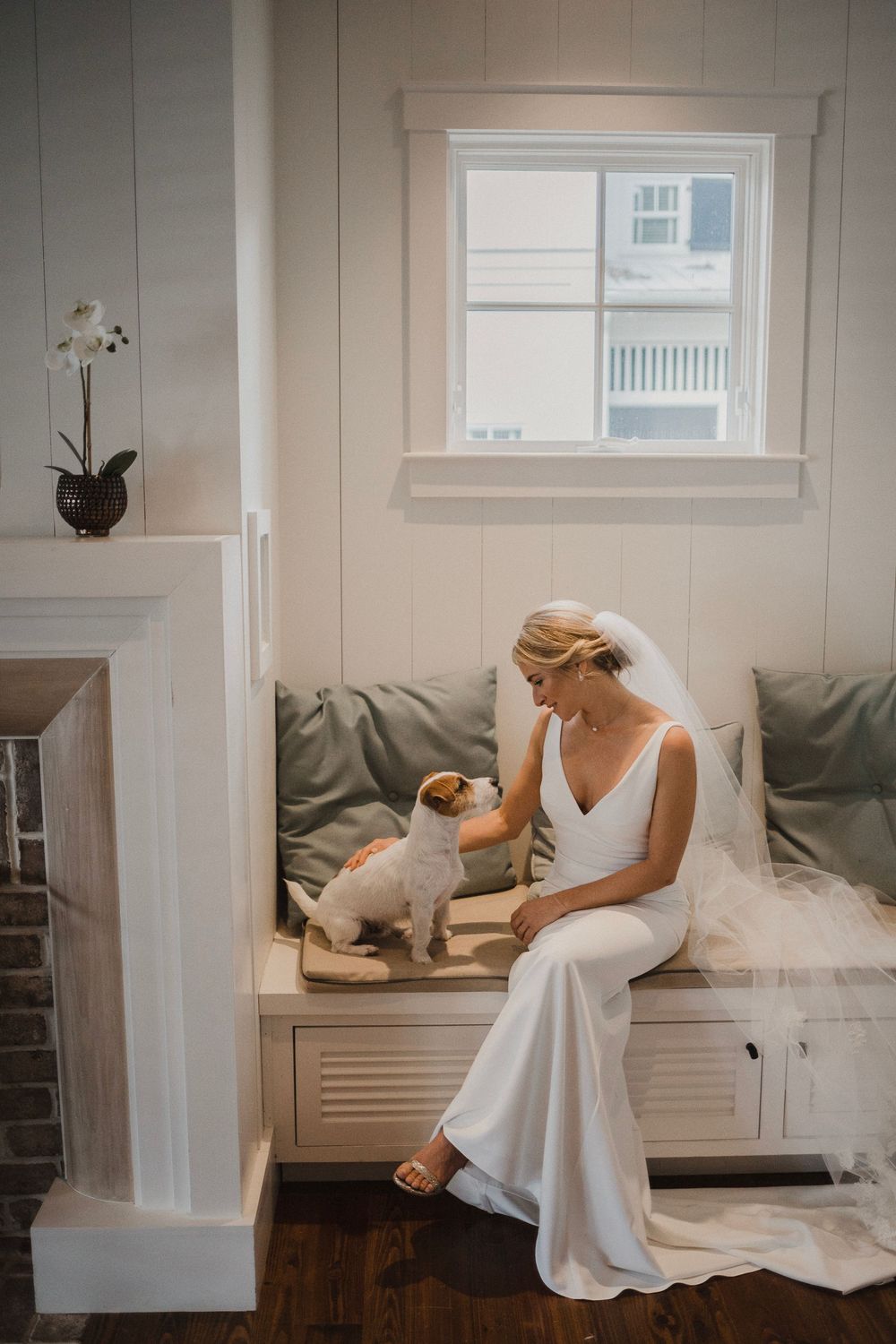 Elegant wedding preparation scene with white dress against built-in bench seating.