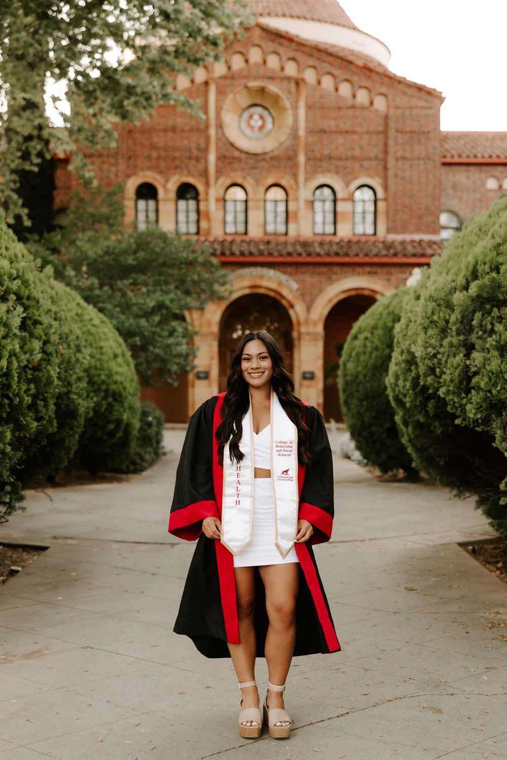 A series of graduation portraits taken in front of a Spanish-style brick building with arched windows.