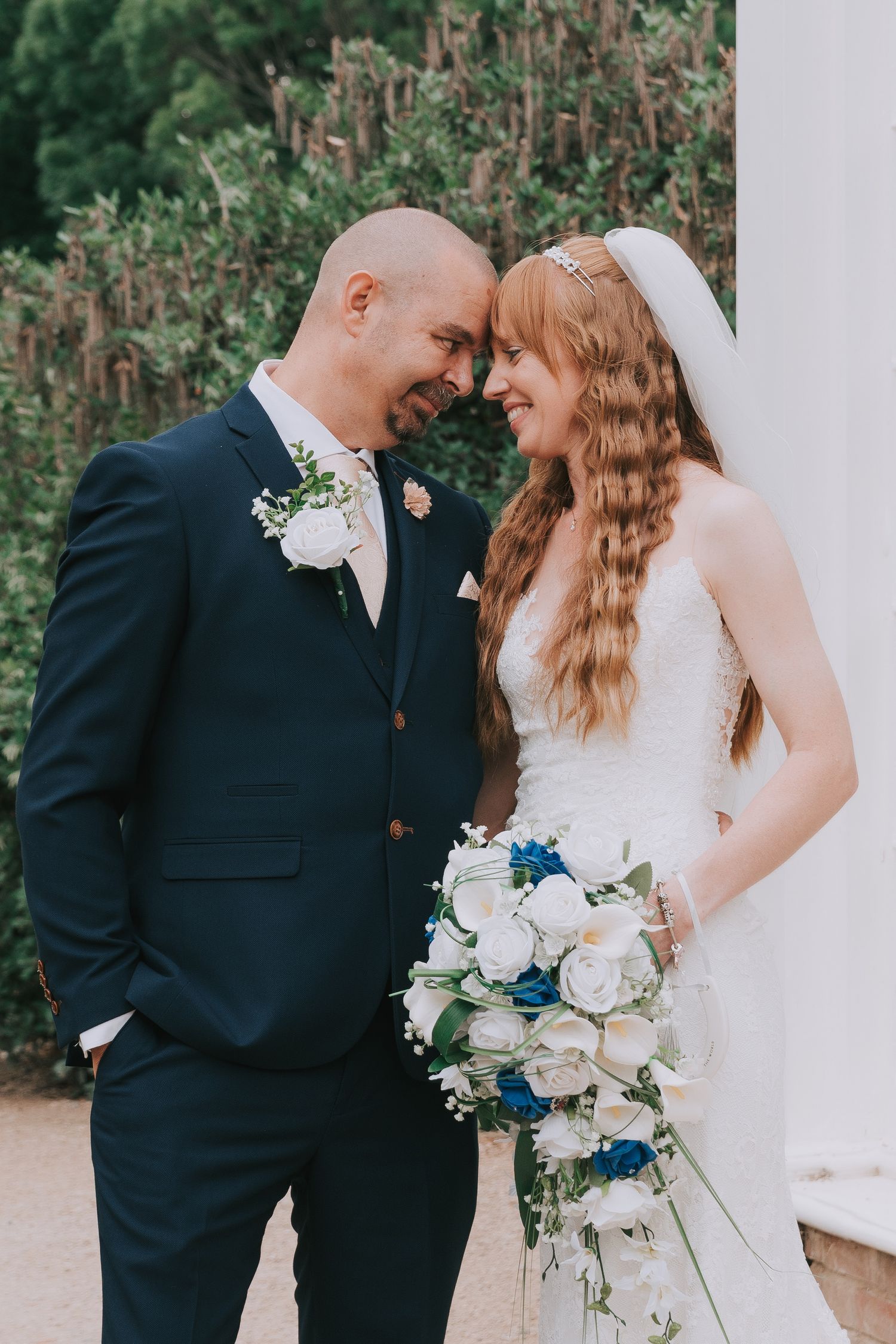 A romantic black and white wedding moment captured in a garden with lavender flowers in the foreground.