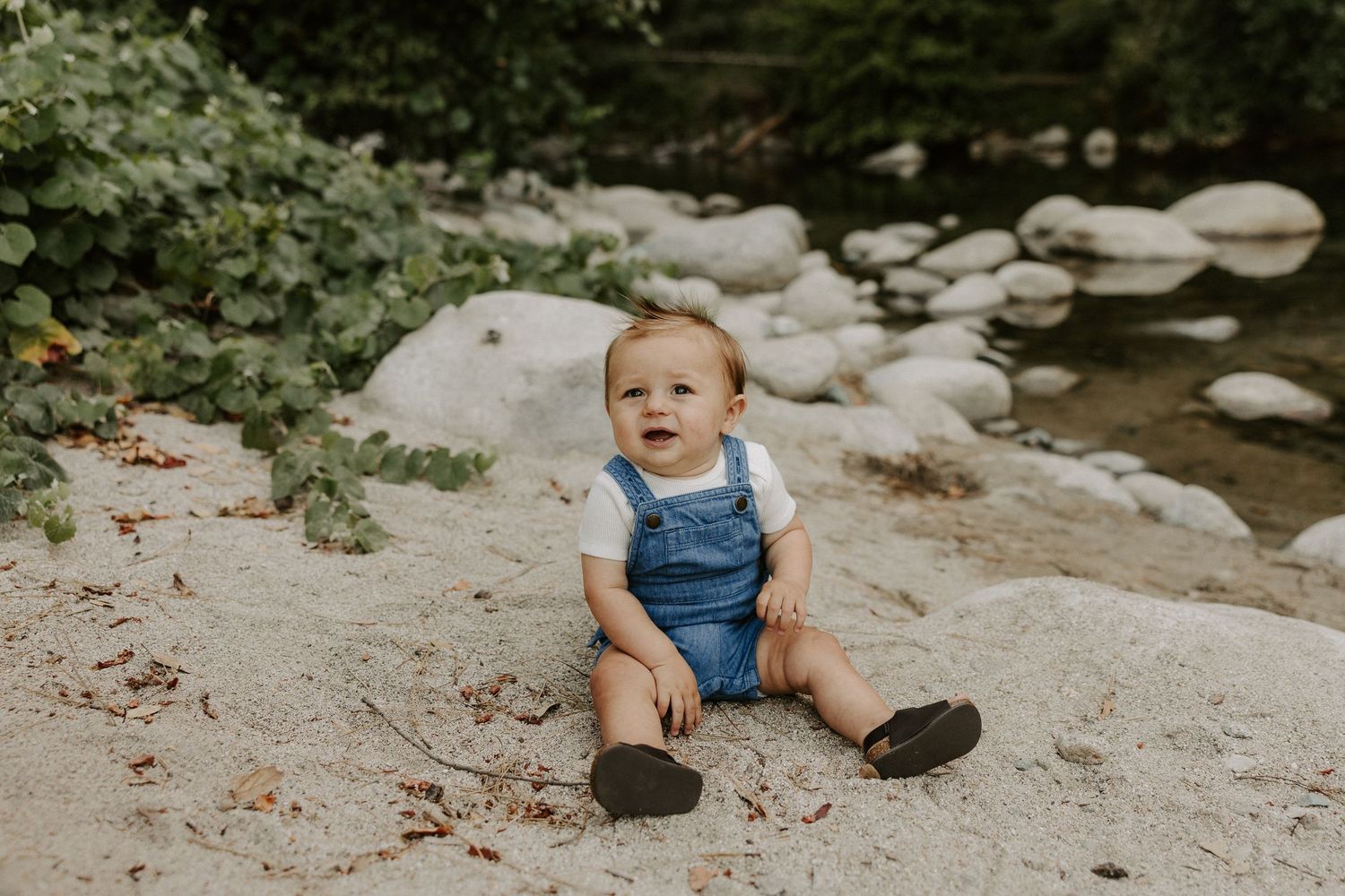 A collection of candid shots showing a toddler in denim overalls playing outdoors on rocky terrain.