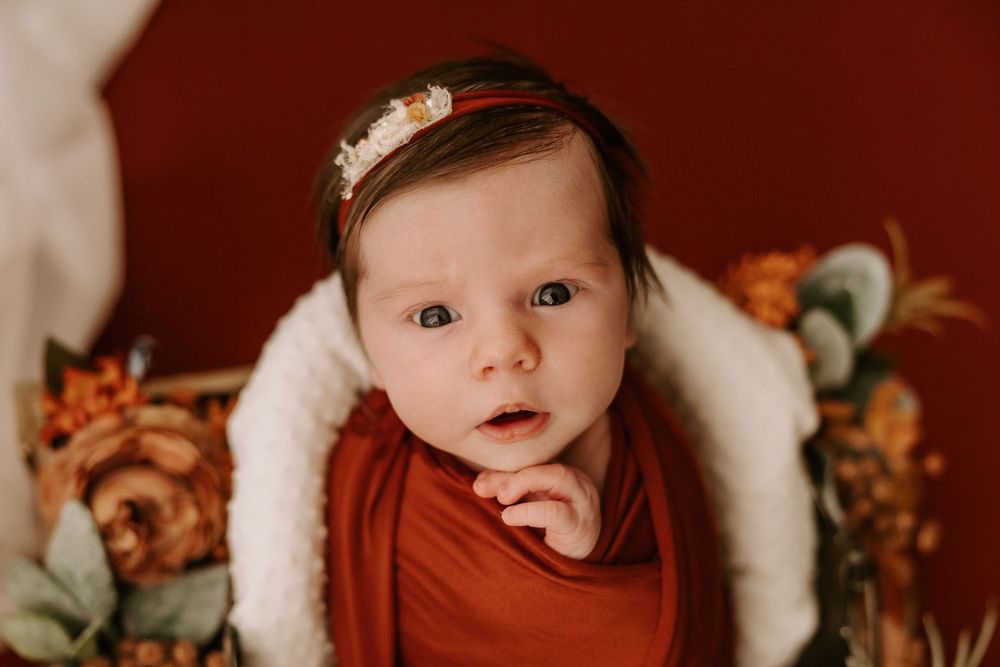 A collage of baby photos with a warm rustic brown background showing various expressions and poses.