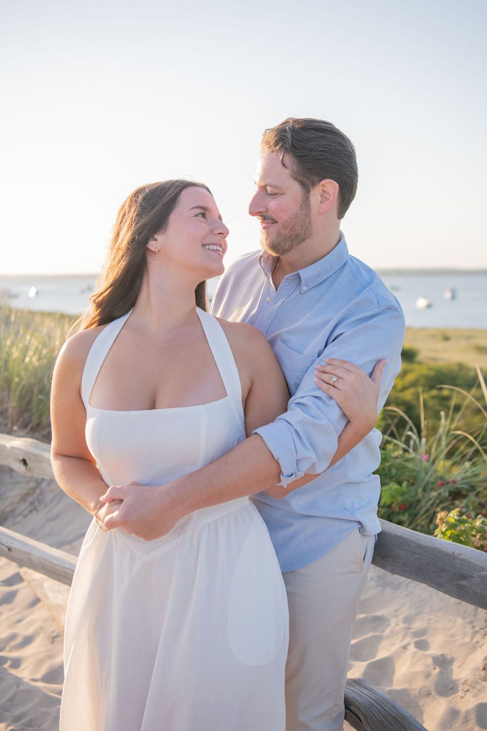Couple shares intimate moments on a sandy beach Rhode Island path during sunset.