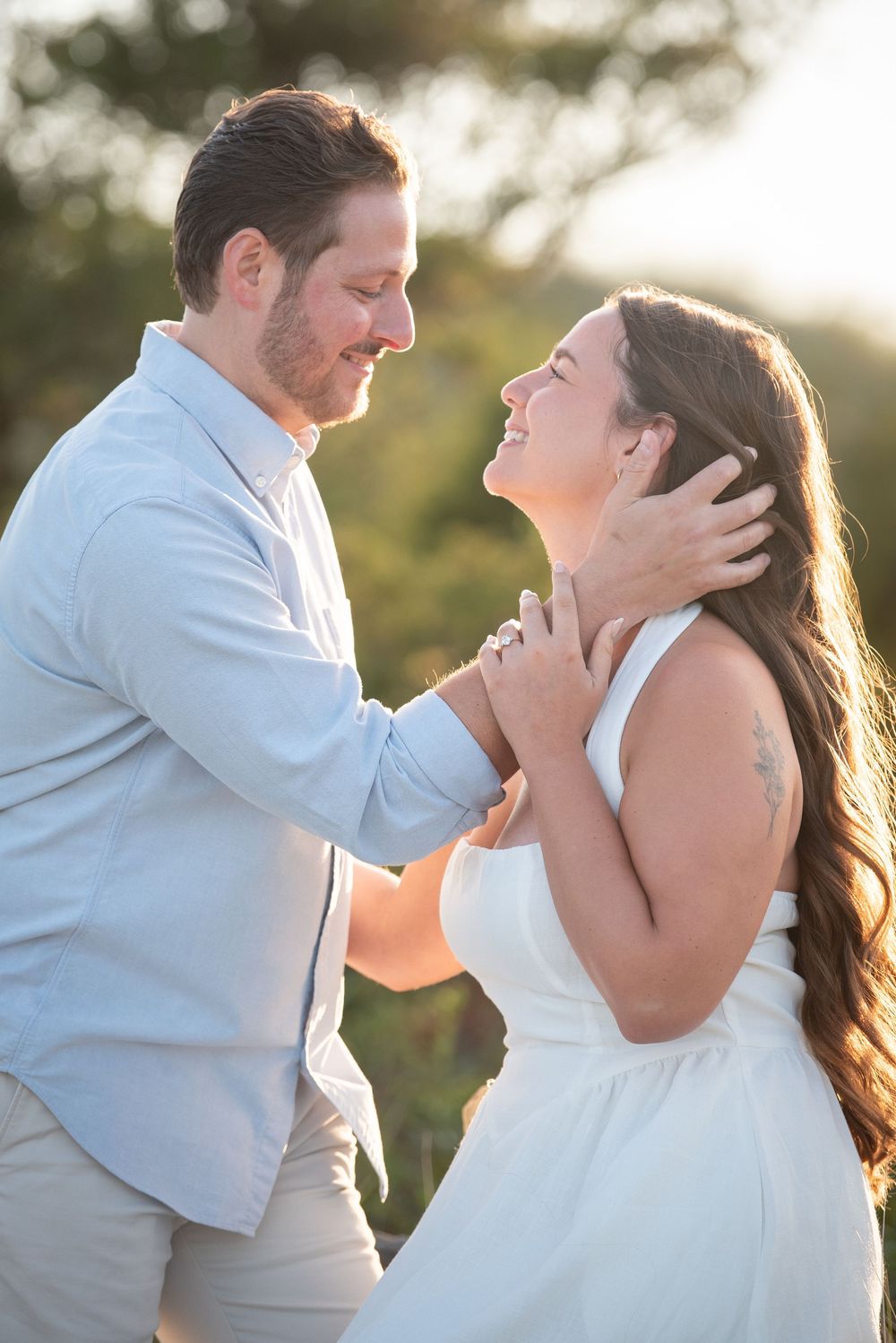 A tender moment between a couple captured in warm sunset lighting.