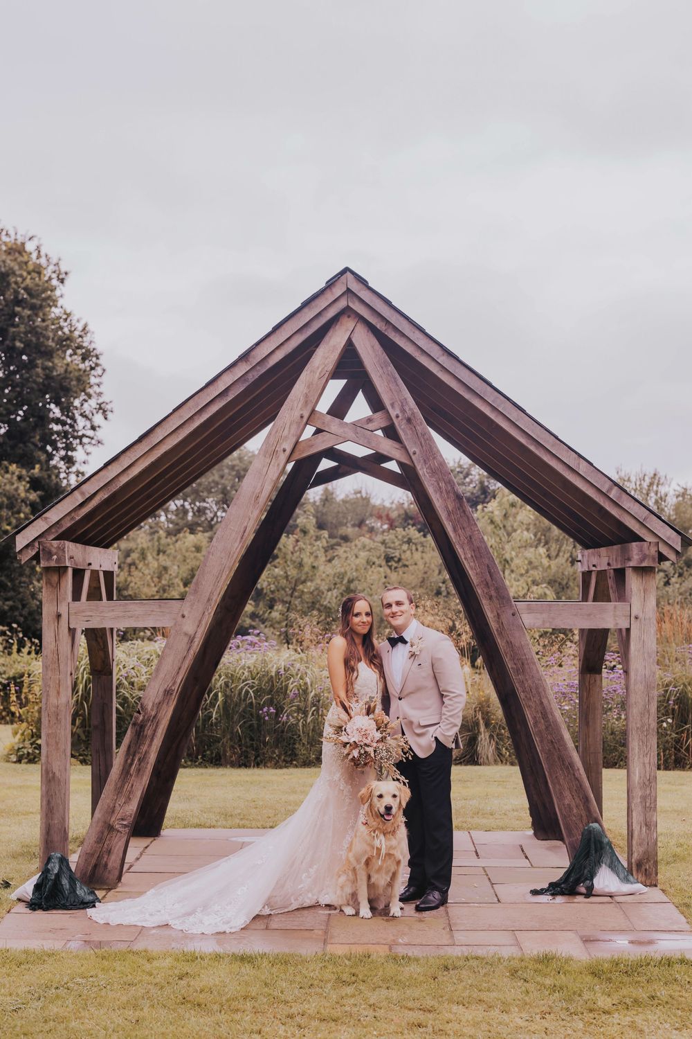 A series of wooden arch structures in a rustic outdoor wedding venue set against a natural landscape.