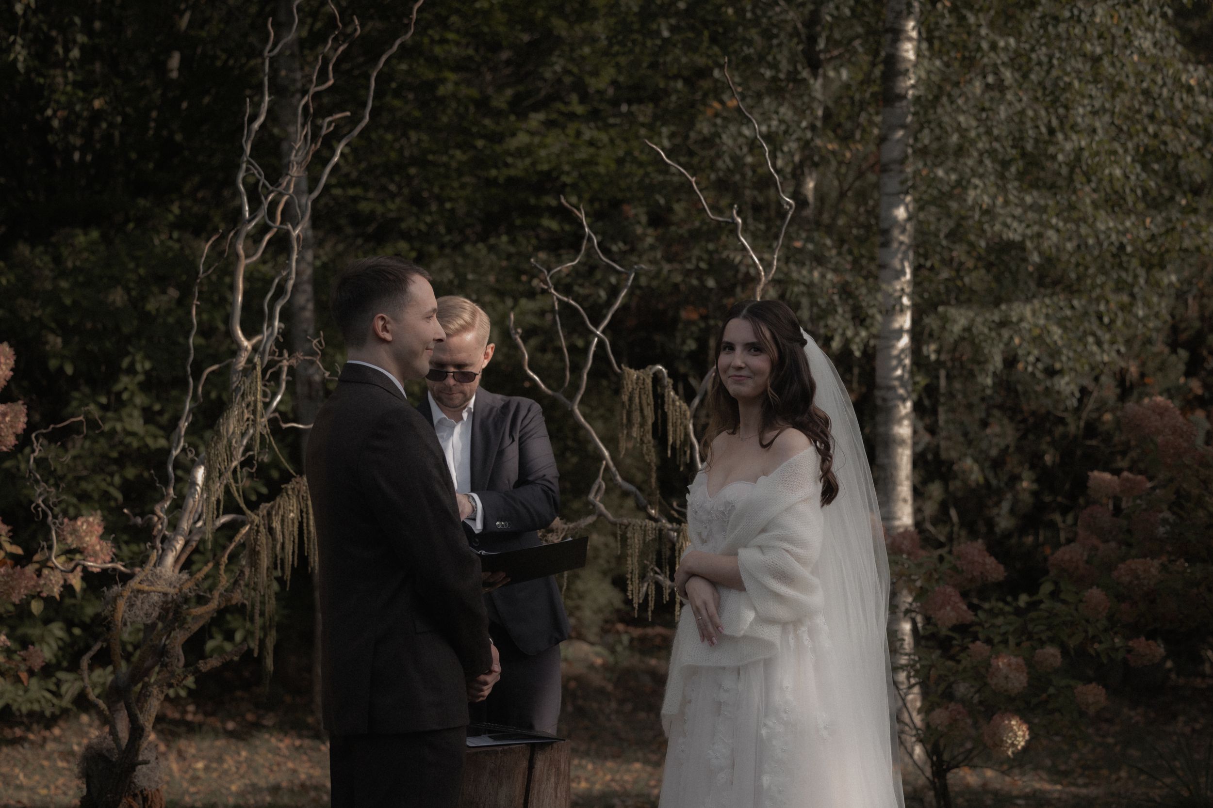 A romantic wedding couple shares intimate moments in a garden setting during their outdoor photo session.