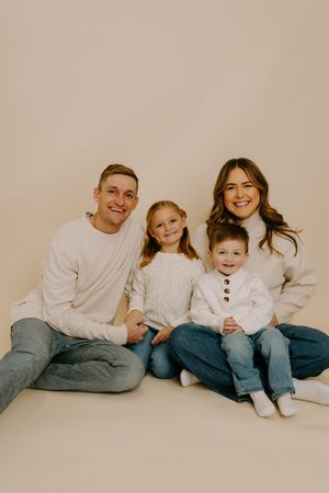 Modern family photo session with everyone in matching white tops and denim.