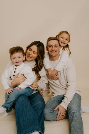 Playful family photo session with everyone laughing and embracing.