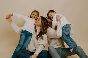 A joyful family photoshoot featuring coordinated casual outfits and natural interactions.
