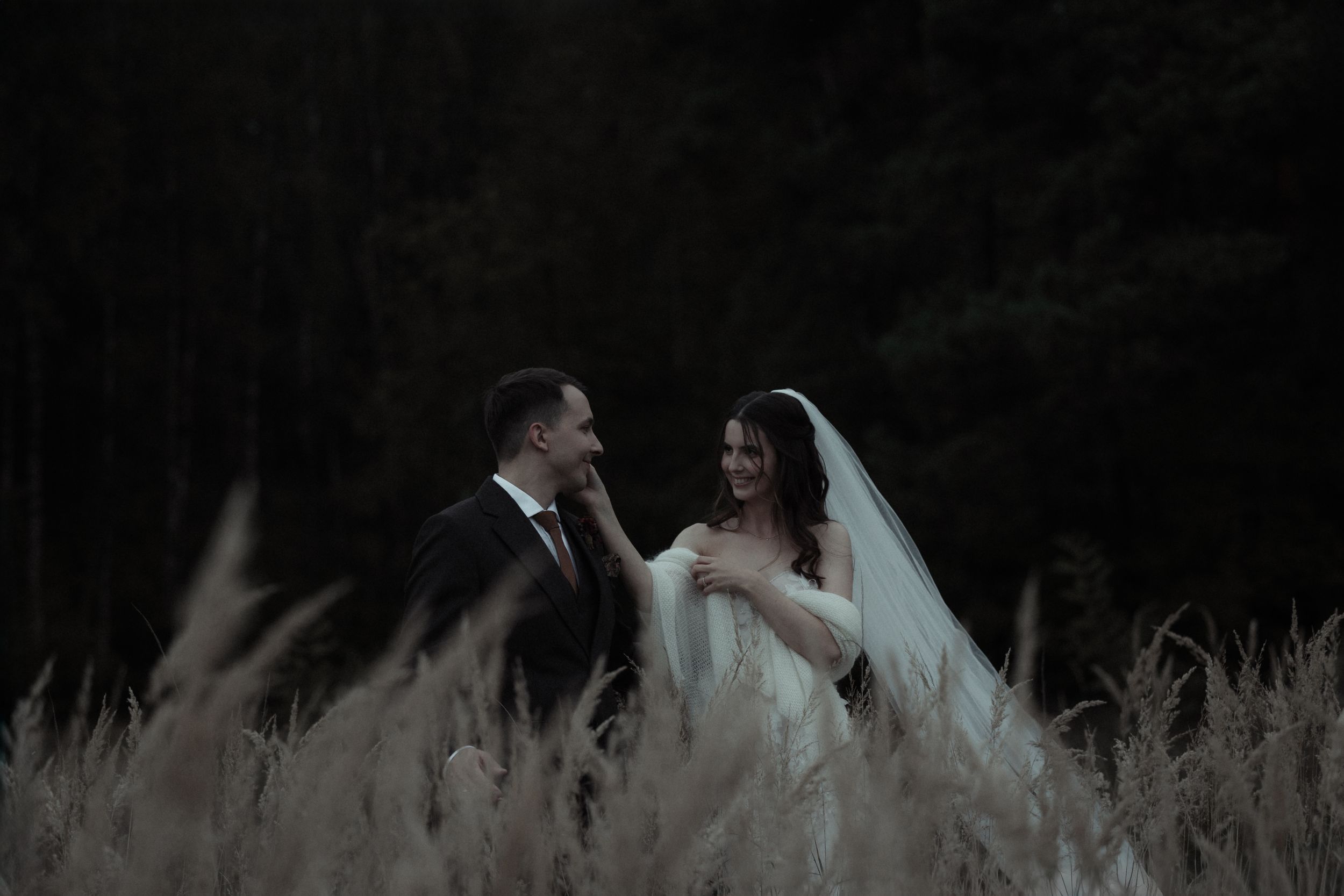 A black and white wedding photo collage showing romantic moments between newlyweds in outdoor settings.