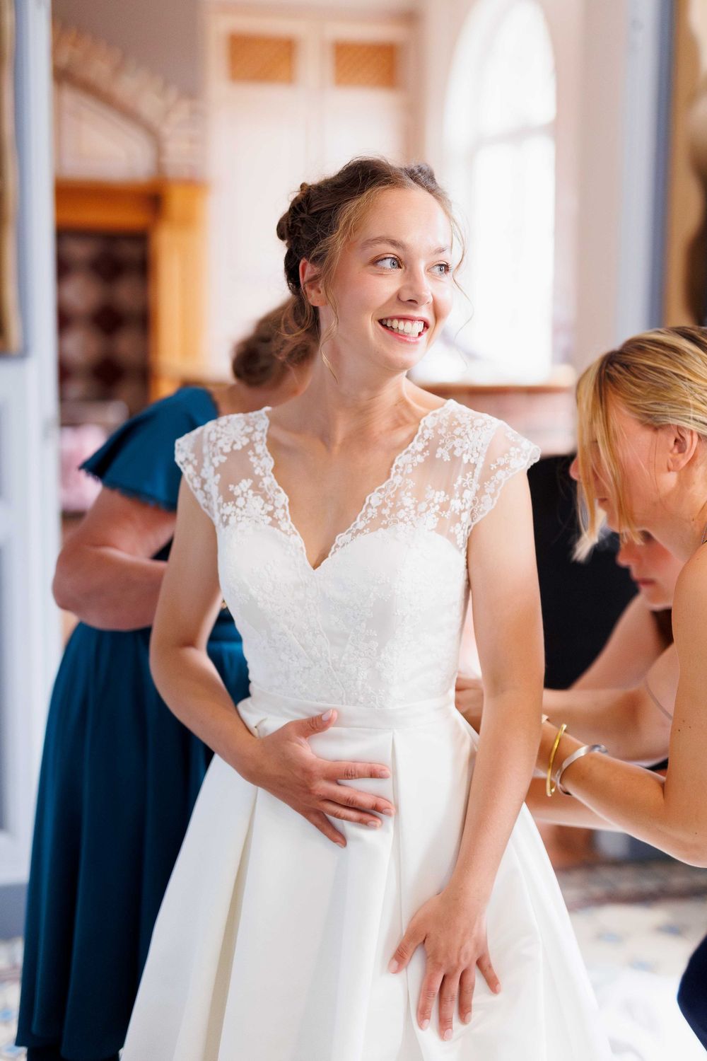 Wedding dress fitting showing intricate lace bodice and full skirt details.