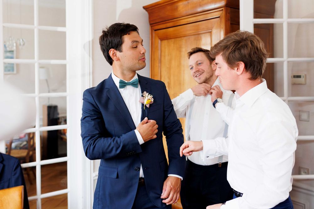 Wedding party members in navy suits and white shirts preparing for ceremony.