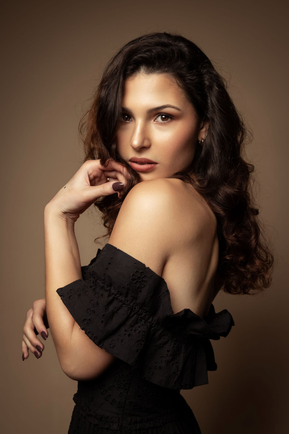 Artistic portrait series showing dramatic poses in black dress against moody brown background with soft lighting.