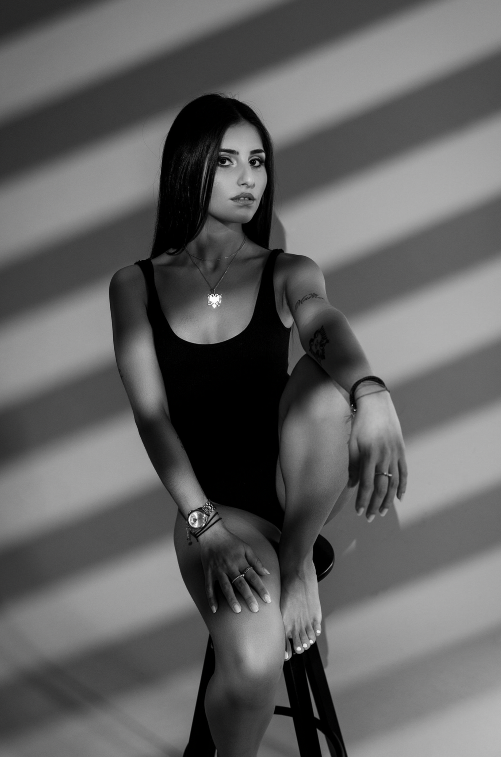 Black and white portrait series with dramatic lighting and shadows creating a moody aesthetic.