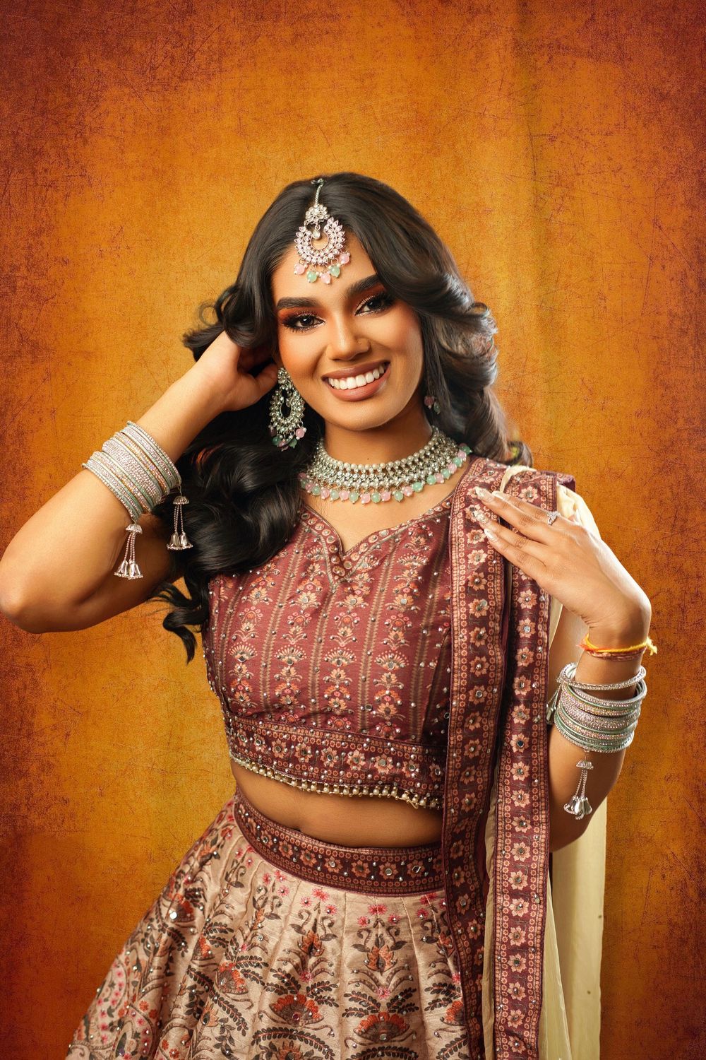 Traditional Indian bridal fashion photo series showing intricate embroidered lehenga and jewelry against warm orange backdrop.