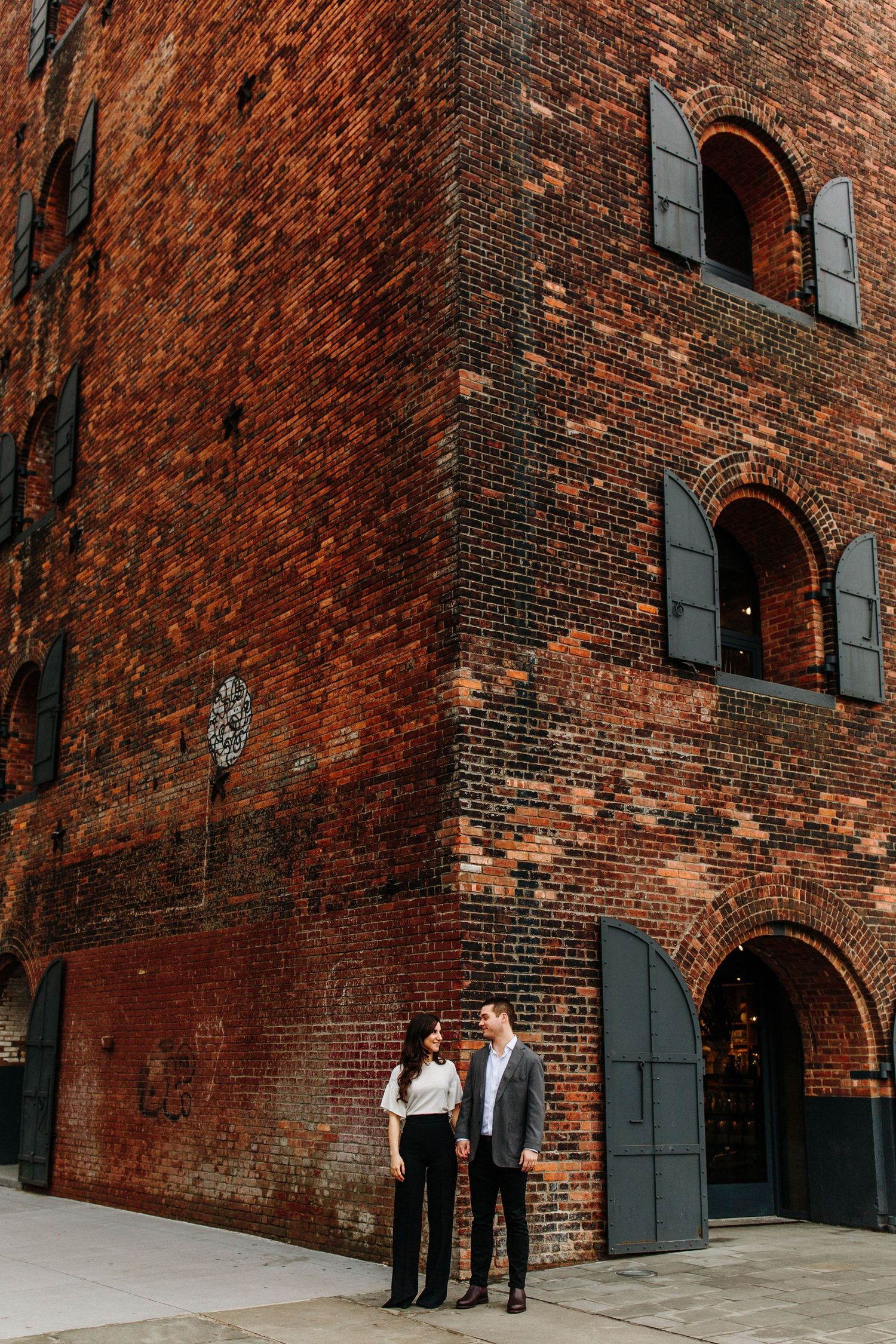 Historic red brick building facade with black shuttered windows in DUMBO Brooklyn.