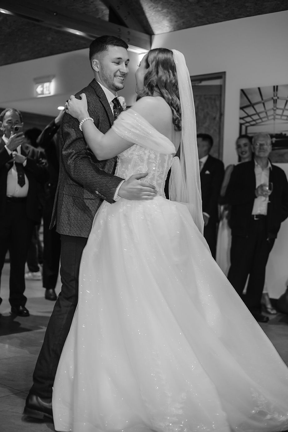 Black and white photos show couples dancing together at a wedding reception in an elegant venue.