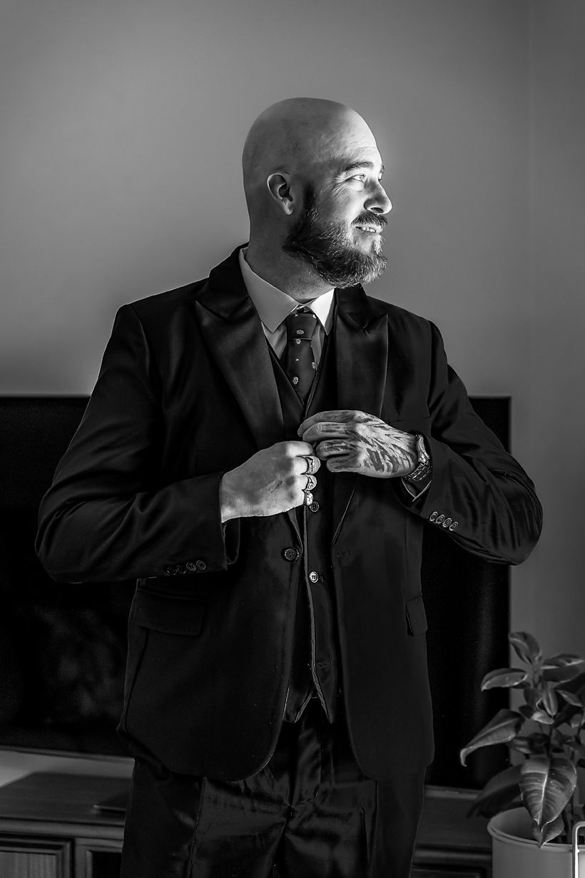 A sequence of black and white photos showing someone adjusting their tie while wearing a formal dark suit.