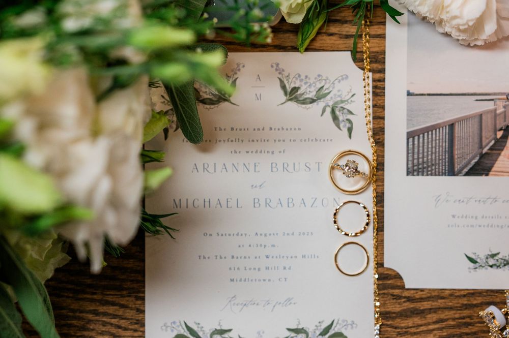 Wedding invitation with delicate greenery design and couple's names in elegant typography.
