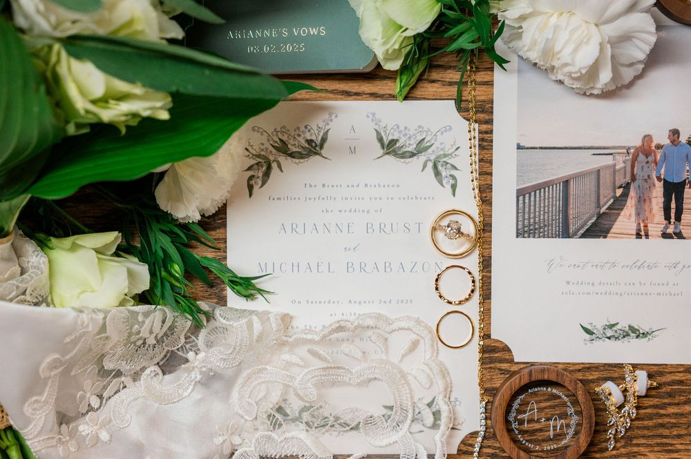 Elegant wedding invitation with floral details and rings styled with white flowers.