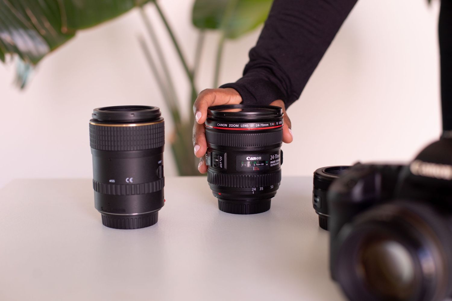 Multiple camera lenses lined up in a row on a white surface showing different focal lengths and sizes.