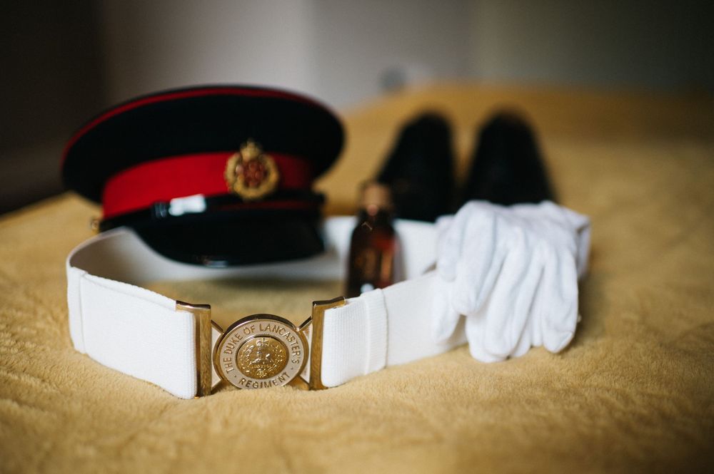 Military dress uniform accessories and details arranged on textured surface.