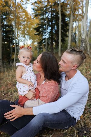 Family sitting together in an autumn forest in Utah during a relaxed outdoor family photography session