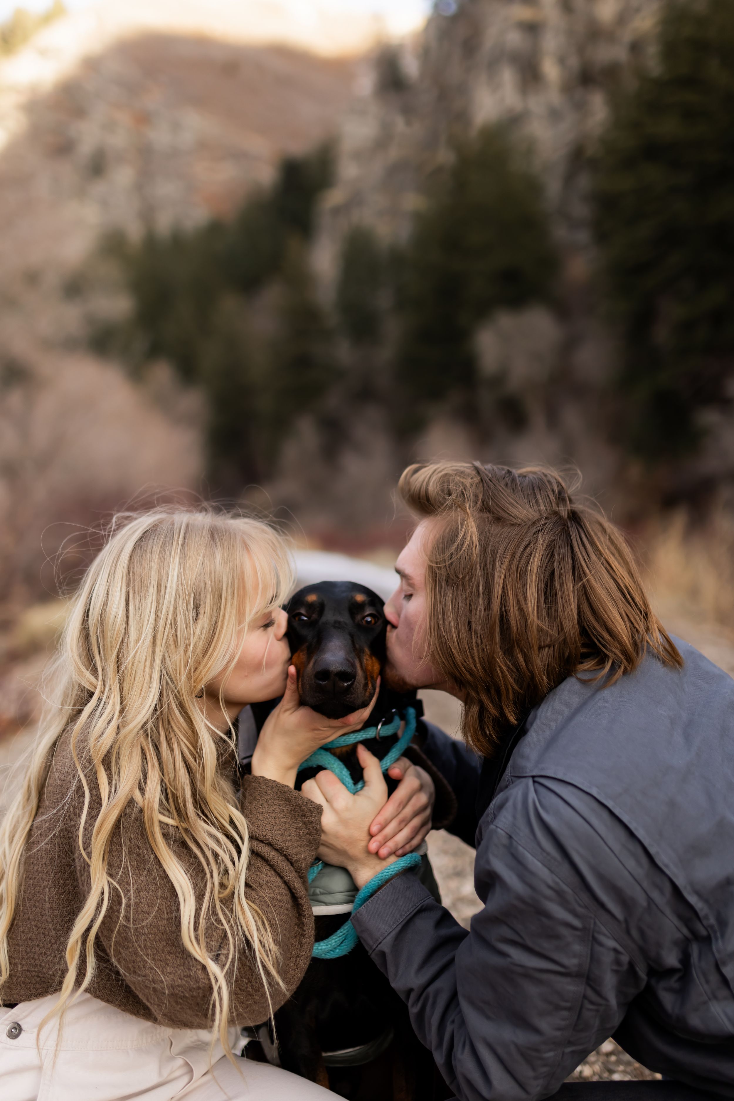 Couple kissing their dog during a cozy outdoor couples session in Utah
