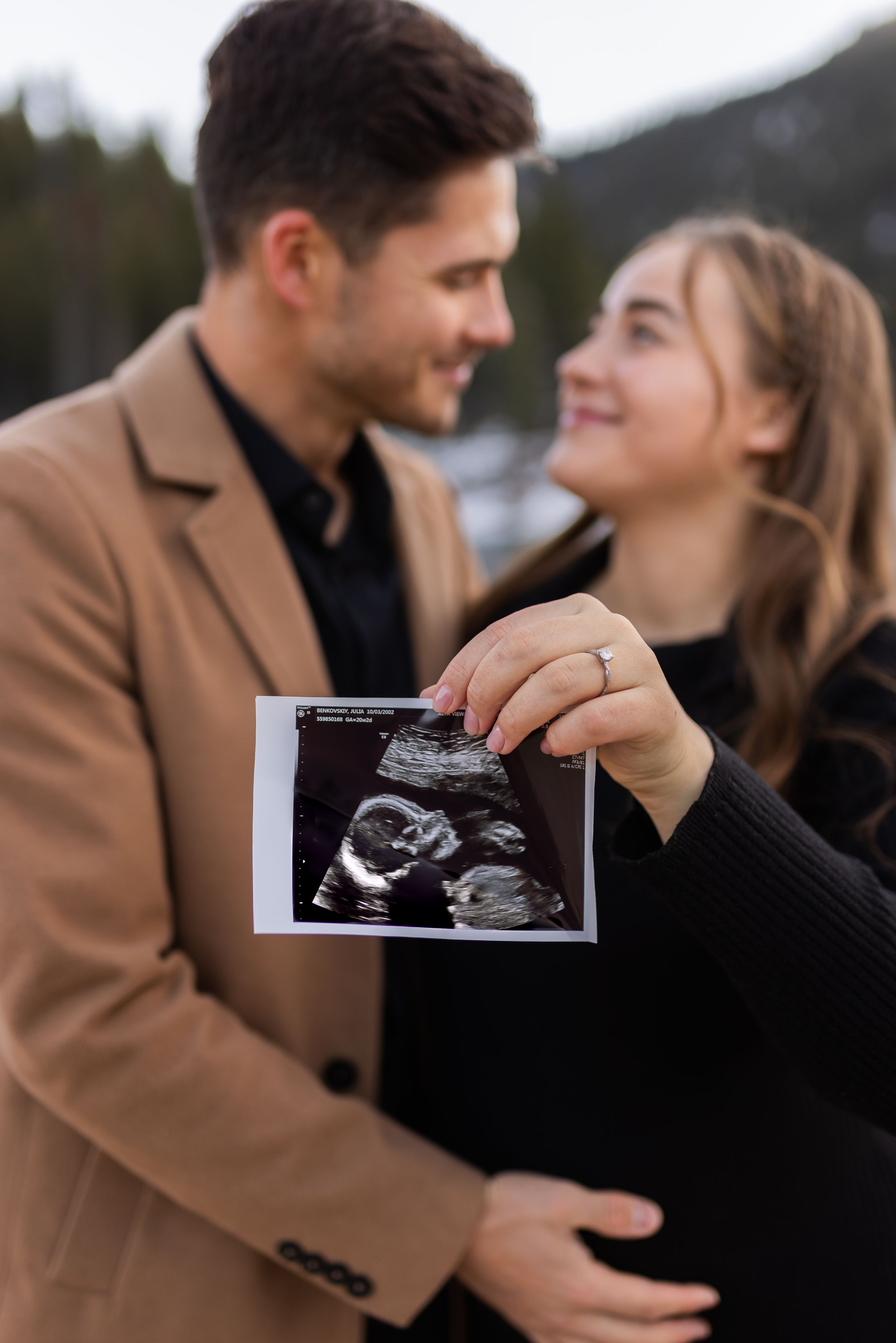 Expecting couple holding ultrasound photo during a Utah maternity photography session