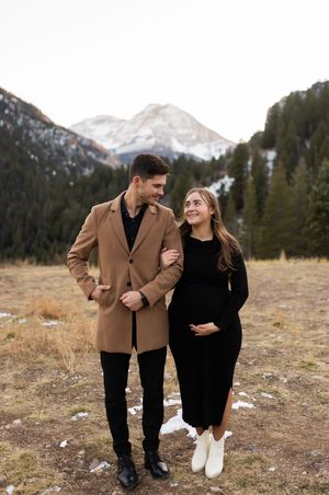 Pregnant couple walking together in the mountains during a Utah maternity photography session