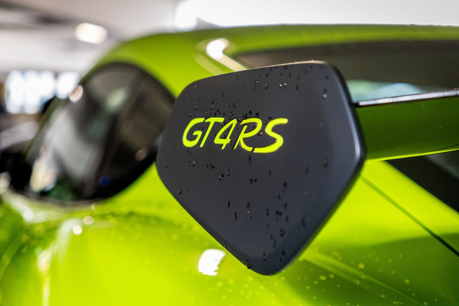 A bright green motorcycle handlebar grip with black controls and metallic accents in natural lighting.