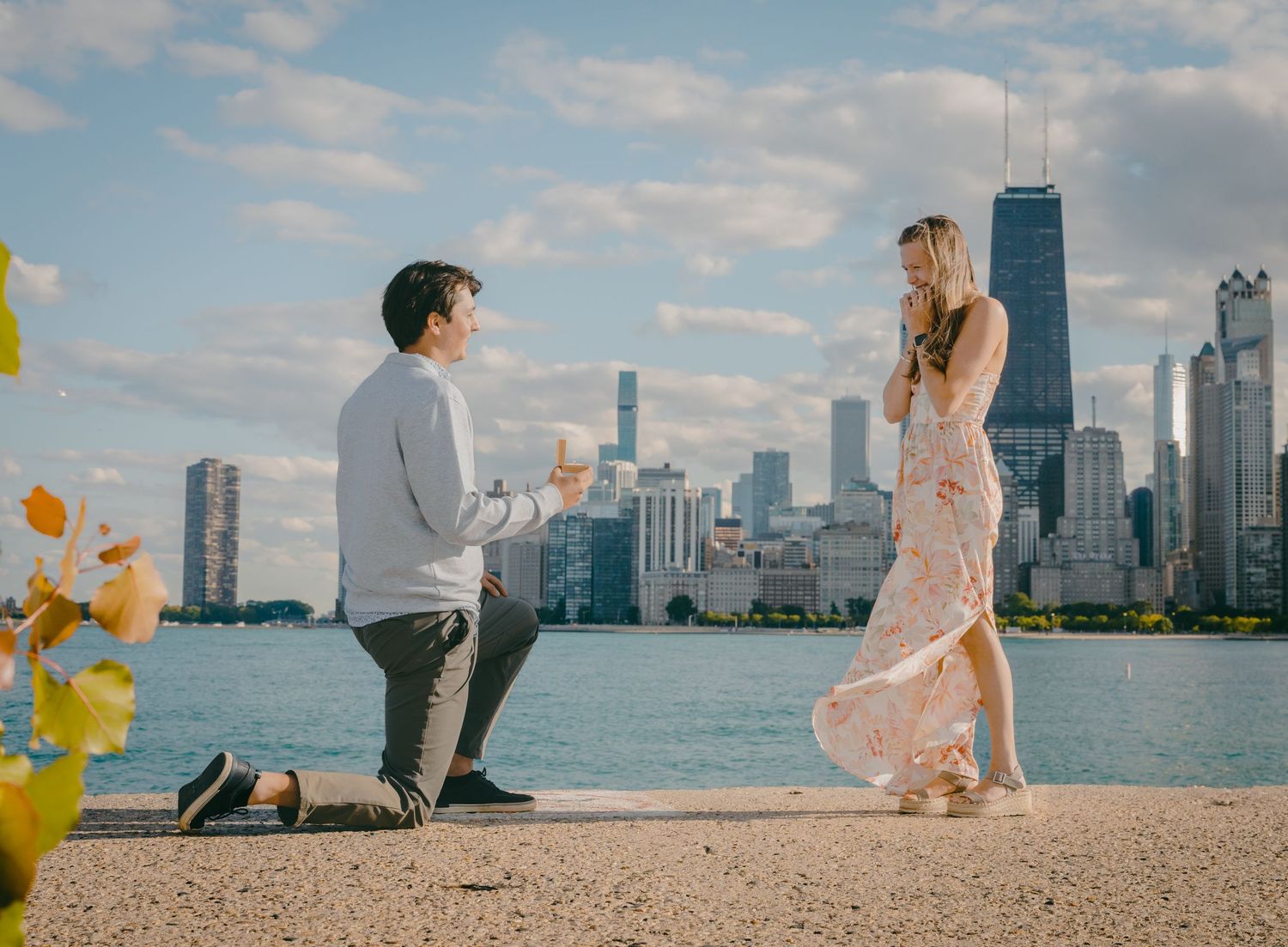 A couple shares a romantic moment during their engagement photoshoot along Chicago's North Avenue Beach with the skyline view.