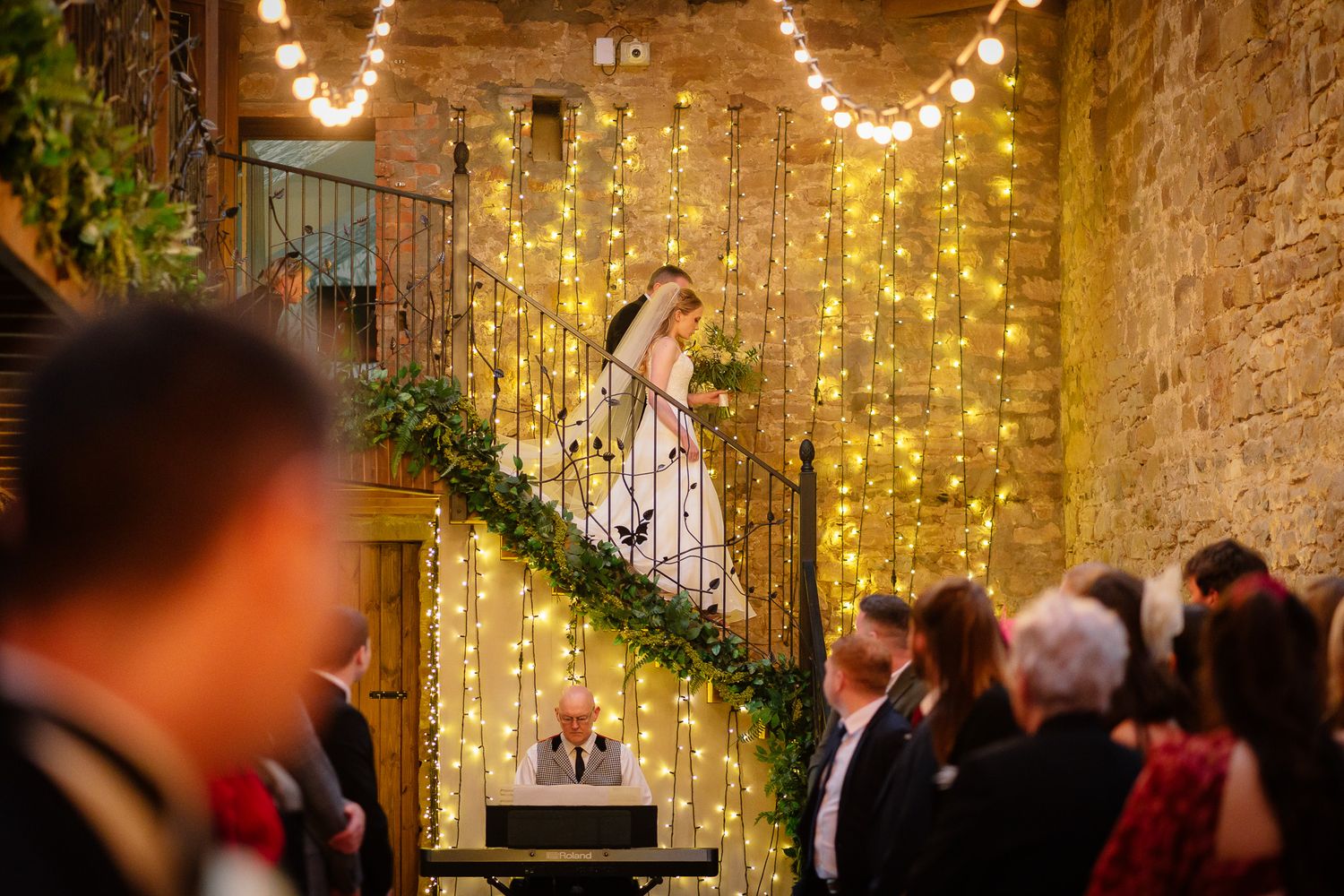 Rustic barn wedding venue decorated with romantic string lights and greenery creating a warm ambiance.