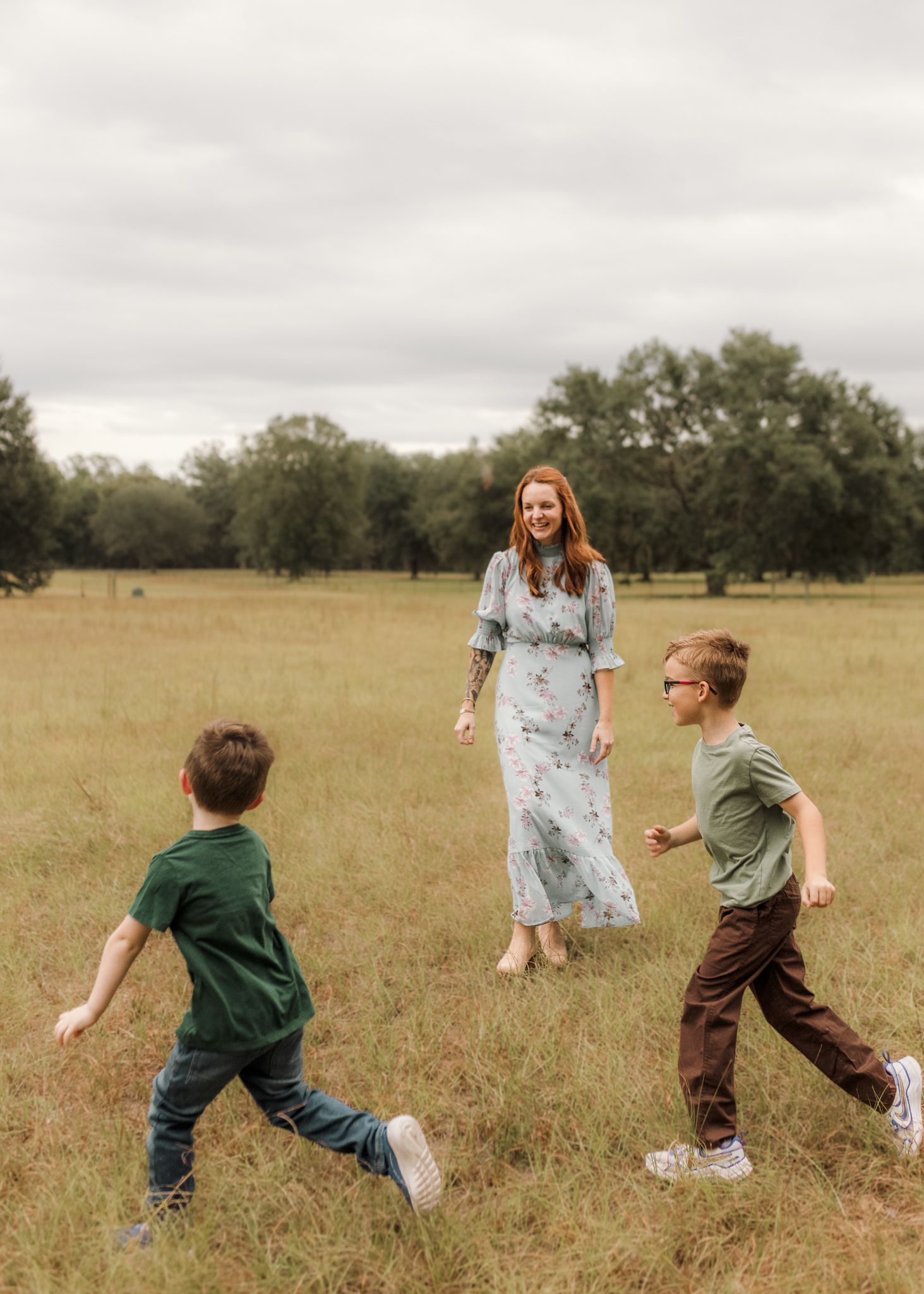 A joyful family plays together in a golden field during sunset, creating a whimsical and candid moment.