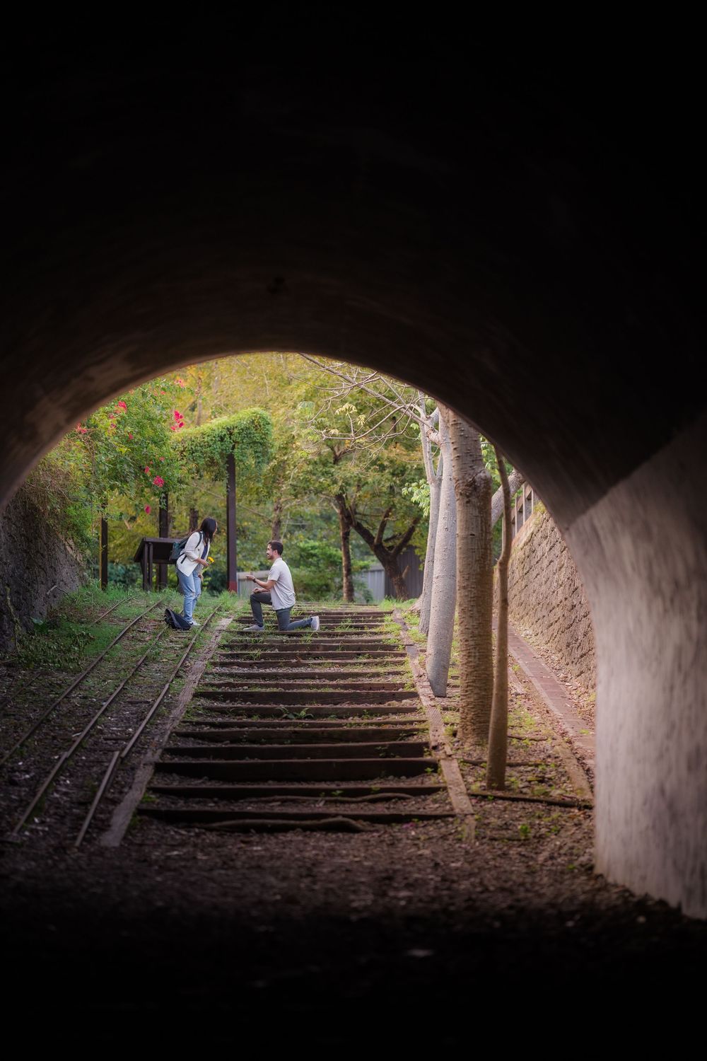 A sequence of tunnel-like archways leading to a sunlit garden area with stone steps and greenery.