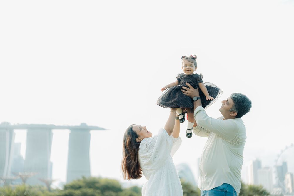 Family playing and posing together with Singapore's Marina Bay Sands skyline in background.